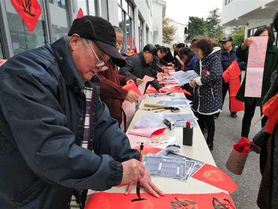 G:《万》127期电子稿部分《万》127期1版照片新闻 2迎新写春联（供稿  办公室）.jpg